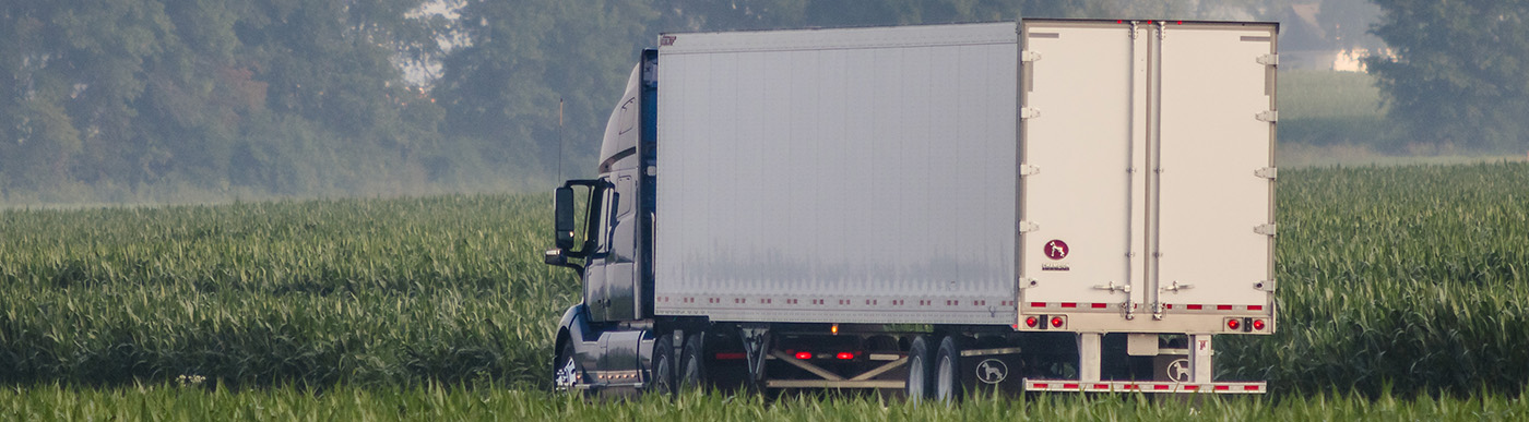 semi trailer driving in a field.